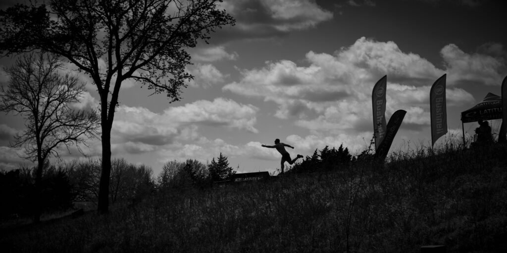 black and white photo with silhouette of disc golfer putting credit to @discgolfprotour