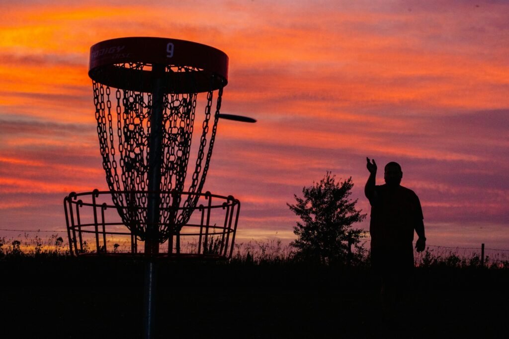 A silhouette of a man throwing a frisbee